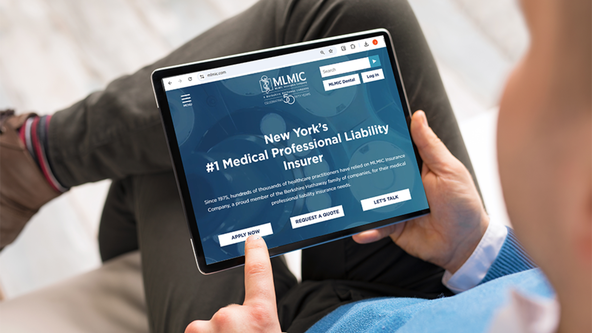 Person using a tablet to browse the MLMIC Insurance website, New York’s leading medical professional liability insurer, with a focus on applying for coverage.